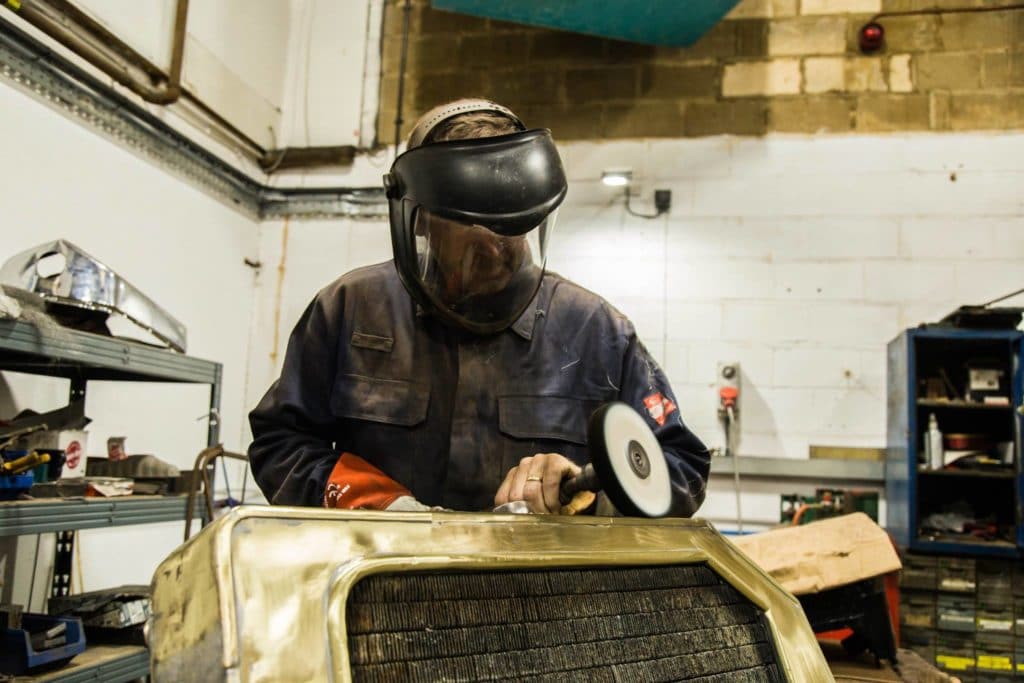 Mechanic smoothing the edge of a radiator